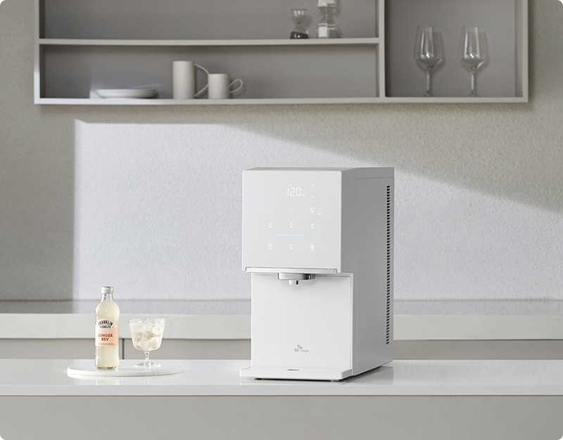 사계절 시원한 얼음을 즐기는 SK매직 얼음 정수기: 번거롭게 얼음을 얼릴 필요 없이 바로 추출하여 아이스 아메리카노를 만드는 모습. 모던한 주방 선반 앞에 놓인 화이트 컬러의 세련된 얼음 정수기 연출 이미지