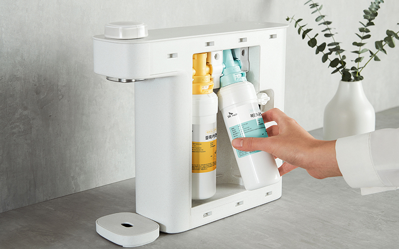 SK매직 정수기 필터 셀프 교체 방법: 사용자가 직접 프리 블록카본 필터와 복합 나노 PAC 필터를 간편하게 갈아 끼우는 모습. 정기적인 필터 교체로 물의 품질 저하와 세균 번식을 예방하고 깨끗한 직수 성능을 유지하는 위생 관리 가이드 이미지